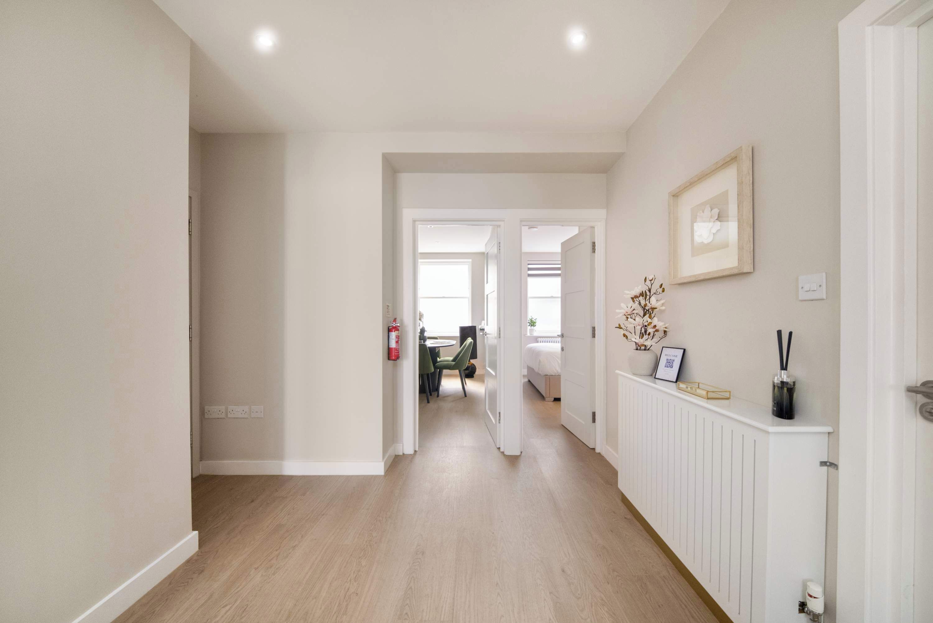 A hallway with a radiator, a framed picture, and a fire extinguisher.