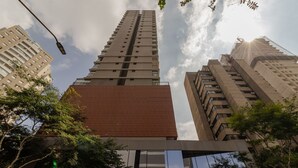 Ein Hochhaus mit mehreren Stockwerken, großen Fenstern und einer Mischung verschiedener Baustile.