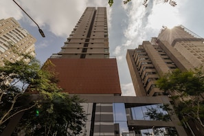 Ein Hochhaus mit mehreren Stockwerken, großen Fenstern und einer Mischung verschiedener Baustile.