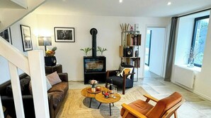 Un salon moderne avec une cheminée, un escalier et une vue sur l’extérieur.