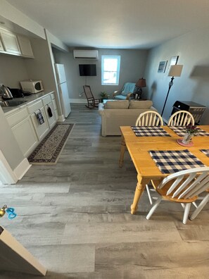 Un espace de vie compact comprenant une cuisine, un coin repas et un espace détente.