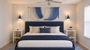 A bedroom with a bed, two bedside tables, a ceiling fan, and a window with blinds. -  1-bedroom condo in gorgeous Sea grove beach , pool and 5 min walk to the beach (Santa Rosa Beach)