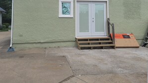 A single-story building with a green exterior, a front door, and a small window. - Cute, newly remodeled bungalow for 7. (Independence)