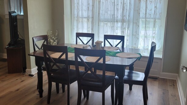 A dining area with a wooden table, chairs, and a chandelier. - Cute, newly remodeled bungalow for 7. (Independence)
