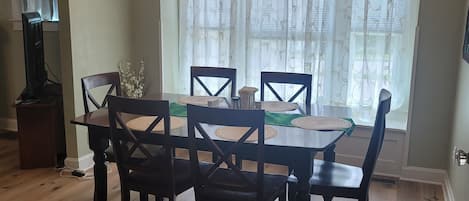 A dining area with a wooden table, chairs, and a chandelier.