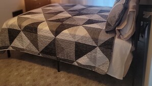 A bedroom with a bed, a nightstand, a lamp, and a window with curtains. - Cute, newly remodeled bungalow for 7. (Independence)