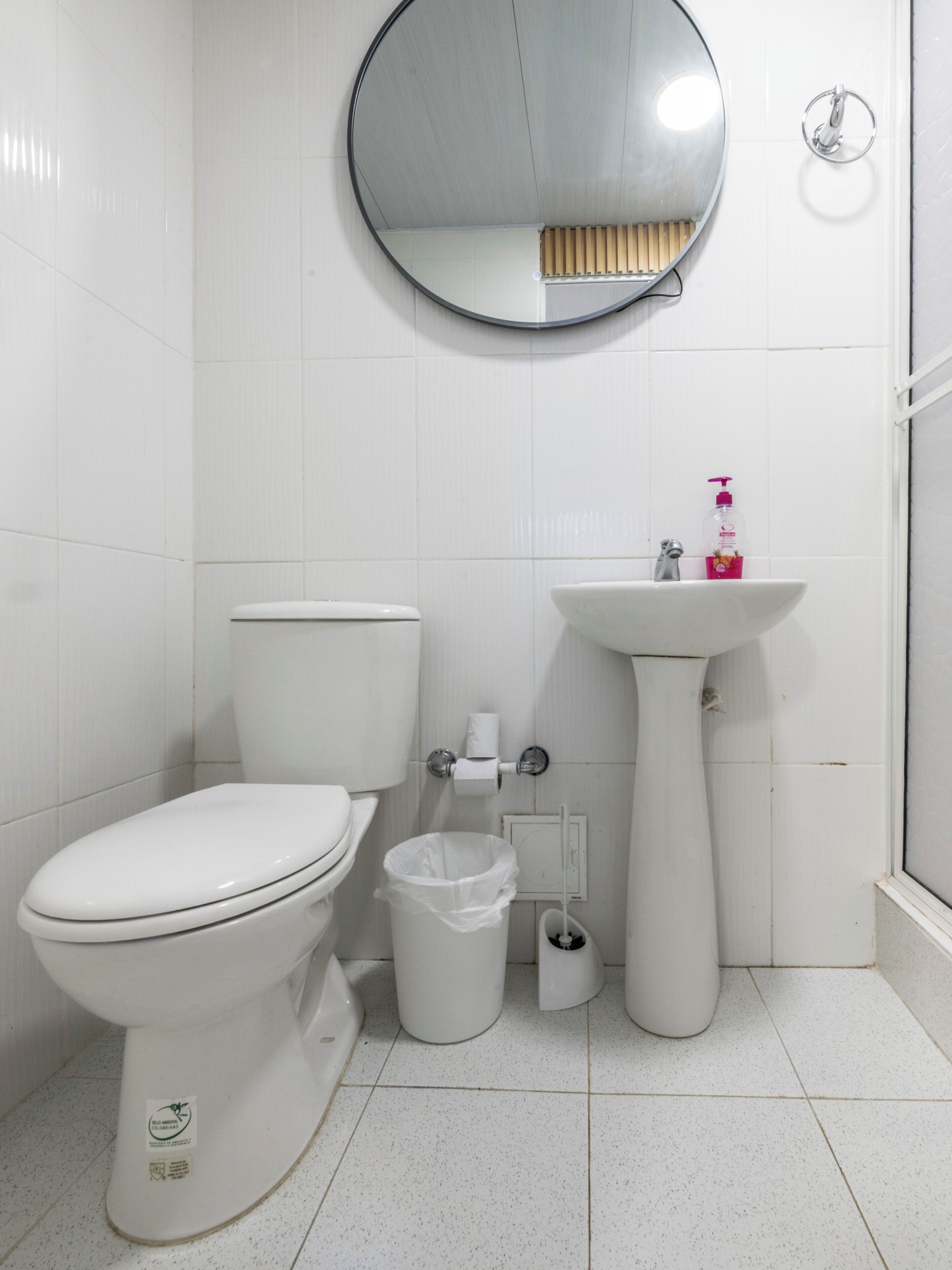 Un baño con inodoro, lavabo y espejo.