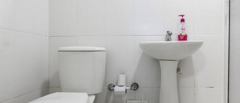 Un baño con inodoro, lavabo y espejo.