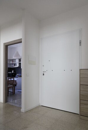 A white door with a handle, a light switch, and a small lock on the door. - Very central, bright and multi-accessorised apartment ideal for families. (La Spezia)