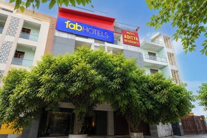 Um hotel com uma grande placa indicando 'fab hotels' e uma placa menor para 'Hotel Aditya Residency'.
