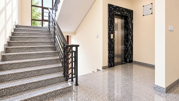 A staircase with a metal railing leading to an elevator.