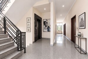 A modern interior with a staircase, polished floors, and framed artwork on the walls. - FabHotel Aqueens Plaza - Near Jawahar Circle, Patrika Gate (Jaipur)