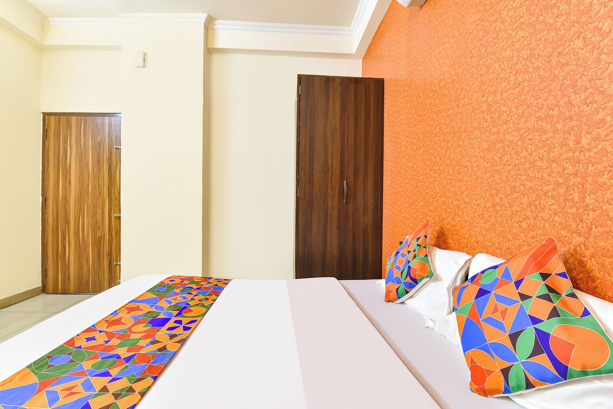 Una habitación de hotel con cama, armario y pared con diseño.