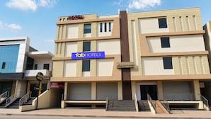 A hotel with a sign for 'HOTEL AQUEENS' and 'fabHOTELS' on the facade.