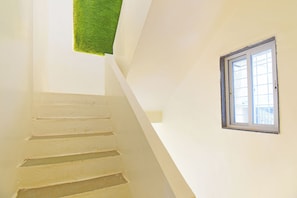 Una escalera con una pared blanca y una ventana.
