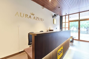 A reception desk with a sign reading 'AURA AZURE' and a logo for '10ab HOTELS'.
