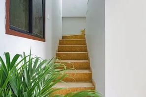 A staircase with a handrail, leading to an upper floor.