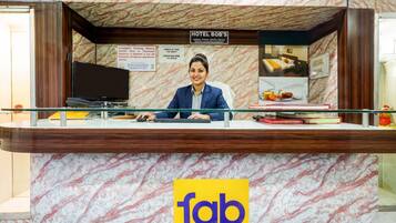 A hotel reception desk with a marble-patterned counter, a sign for Hotel Bob's, and a logo for Fab Hotels.