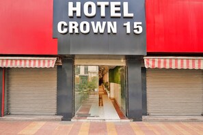 Entrada de hotel com uma placa indicando 'HOTEL CROWN 15'.