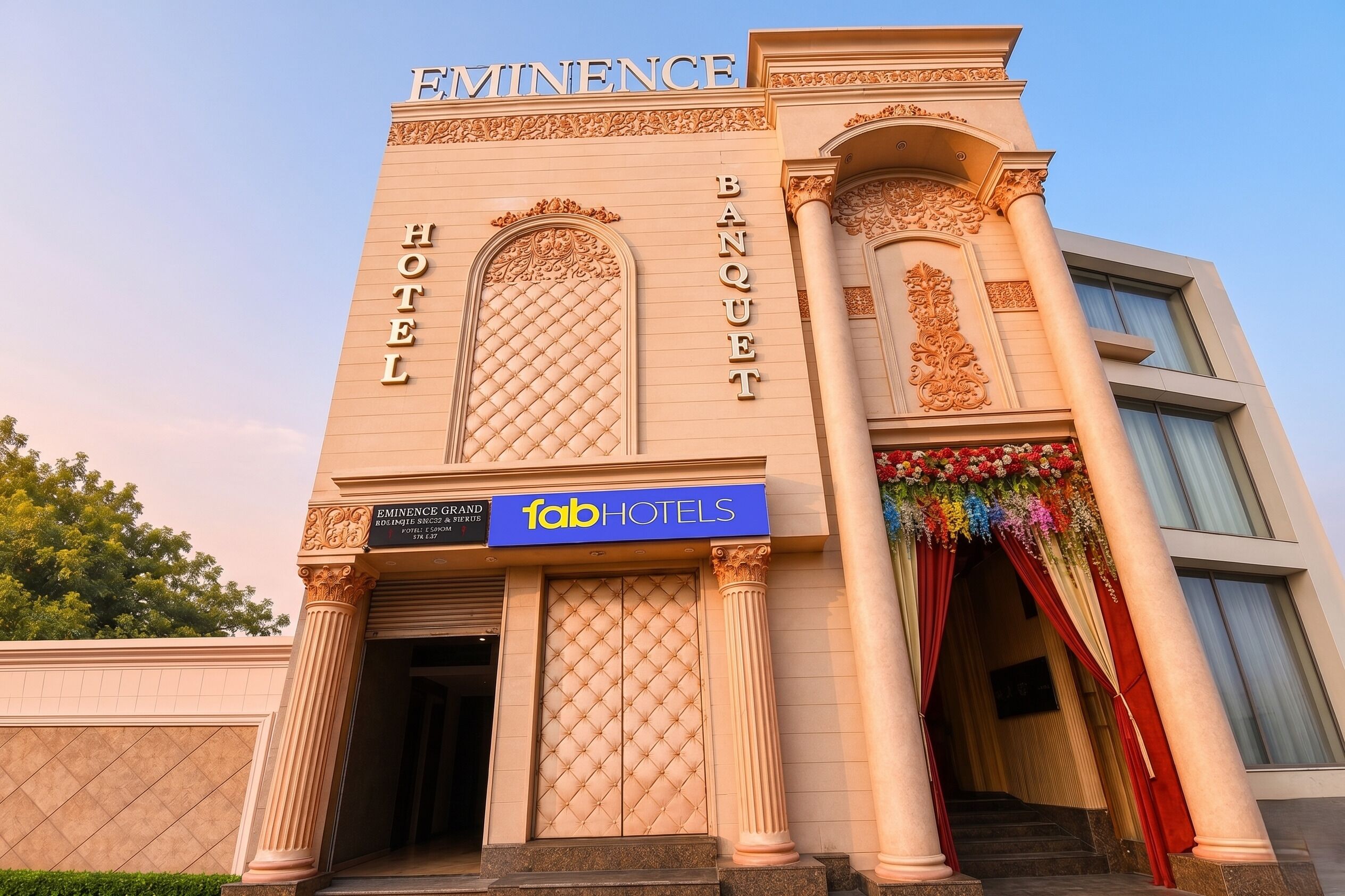 Een hotel met een statig gevelontwerp, zuilen en een bord met 'Eminence Grand Hotels'.