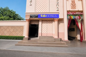 The facade of a hotel with a prominent entrance, a sign for 'Eminence Grand Boutique Hotel & Rooms', and a decorative floral arrangement. - FabHotel Eminence Grand (New Delhi)
