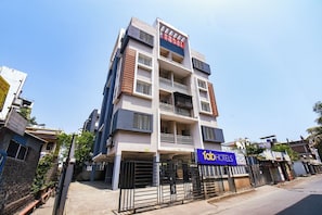 Un edificio de varios pisos con un letrero que dice 'Himalay Guest House' y un letrero de 'FabHotels'.