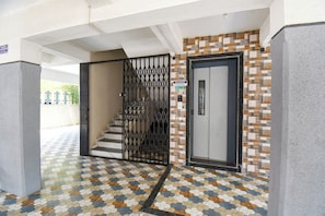 A reception area with a staircase, a reception desk, and a patterned floor. - Fabhotel Himalay Guest House (Pune)