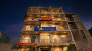 A multi-story hotel with a reception area, balconies, and a sign indicating availability of a hotel HR residency. - Fabhotel Hr Residency (New Delhi)