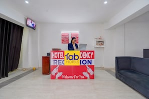 A reception desk with a sign for 'Hotel Fabancy Regency' and a television mounted on the wall. - Fabhotel Hr Residency (New Delhi)