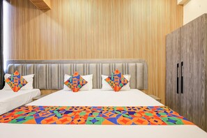 Una habitación de hotel con una cama, cabecera y armario.