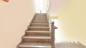 A staircase with granite steps and a metal handrail, leading to a door at the top. - Fabhotel Maru White Lotus (Jaipur)