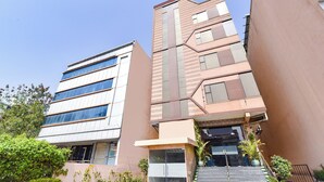 A multi-story building with a modern design, featuring a mix of glass and brick facades, and a staircase leading to the entrance. - Fabhotel Maru White Lotus (Jaipur)