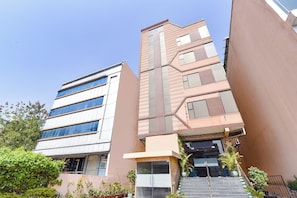 A multi-story building with a modern design, featuring a mix of glass and brick facades, and a staircase leading to the entrance.