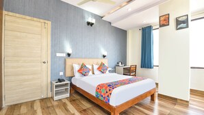 A hotel room with a bed, bedside table, desk, chair, and a wardrobe. - Fabhotel Maru White Lotus (Jaipur)