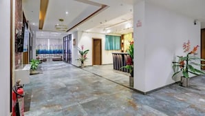 Un hall d’hôtel comprenant un comptoir d’accueil, un espace salon et une grande fenêtre offrant une vue panoramique.