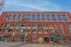 A multi-story building with a prominent Hotel Lacasa sign, multiple storefronts, and a clear sky. - Fabhotel Mh Grand (Kalol)