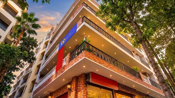 A multi-story hotel with balconies, a red awning, and a sign for 'Hotel'.
