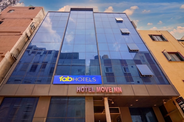 A modern building with a glass facade, a sign for 'fabHOTELS,' and the name 'HOTEL MOVEINN' on the entrance. - Fabhotel Move Inn (Bangalore)