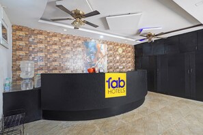 A hotel reception desk with a logo, a clock, and a water dispenser. - Fabhotel Move Inn (Bangalore)