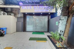 La entrada a un edificio con un letrero que dice 'BLUE SAPPHIRE RESIDENCY'.