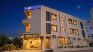 Un hotel moderno con un letrero que dice 'fabHOTELS' y 'OJAS INN' en la fachada.
