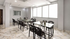 Una sala de conferencias con suelo de mármol, un ventanal grande y un diseño moderno en el techo.