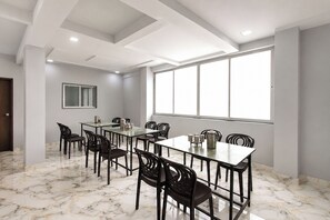 A conference room with a marble floor, a large window, and a modern ceiling design.