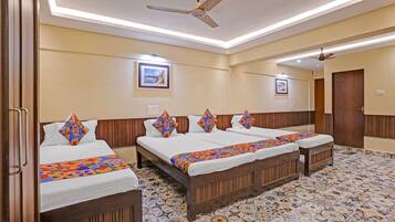 A hotel room with two beds, a ceiling fan, and a tiled floor.