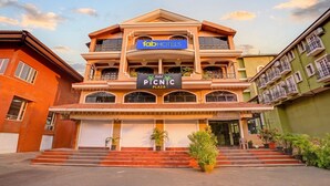 A multi-story building with a prominent 'fabHOTELS' sign, a 'PICNIC' sign, and a 'Hotel' sign on the facade.