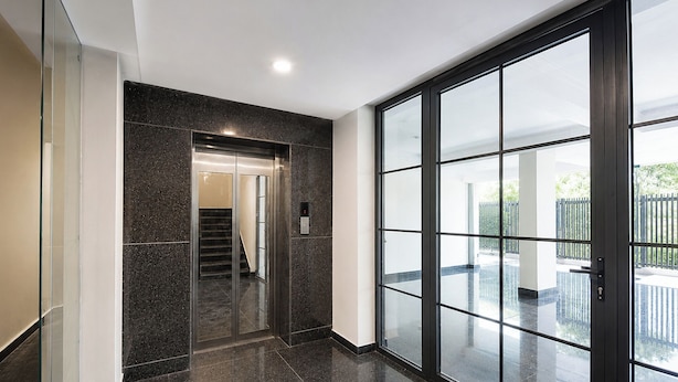 A modern interior with a glass door leading to a balcony, a staircase, and a ceiling light. - FabHotel Prime Hush & Suites - Manesar and Sector 86 (Gurugram)