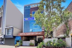Un edificio moderno con un letrero que indica 'fabHOTELS' y 'HOTEL KARTAR GRAND', señalando que es un hotel.