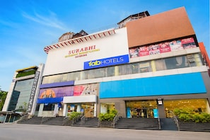 A multi-story building with signage for Surabi, a restaurant, banquets, and rooms. - Fabhotel Prime Surabhi Elite (Hyderabad)