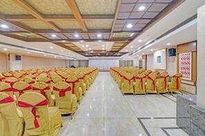 A large hall with rows of chairs, a stage, and a high ceiling with lighting fixtures. - FabHotel La Vista In Kothapet (Hyderabad)