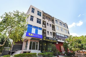 Un edificio de varios pisos con un letrero que dice 'fab HOTELS' y 'HOTEL RAGHUKUL'.